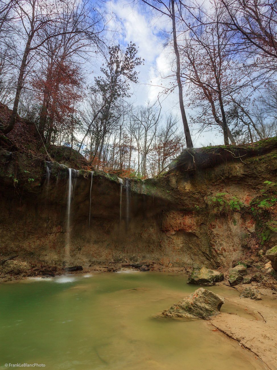 One of several waterfalls in the Clark Creek Natural Area. The cut in the bank shows the colors of clay, green moss and exposed...