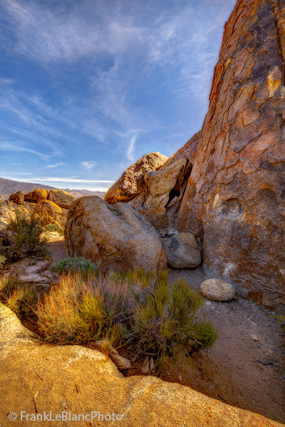 A shady retreat for rock-climbers? The white rock at the base of this large vertical boulder was placed there to help climbers...