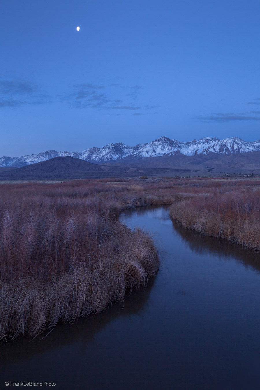 Looking southwest, a waning gibbous moon lights the Owens river valley and the Sierra Nevada mountains. The mountain just right...