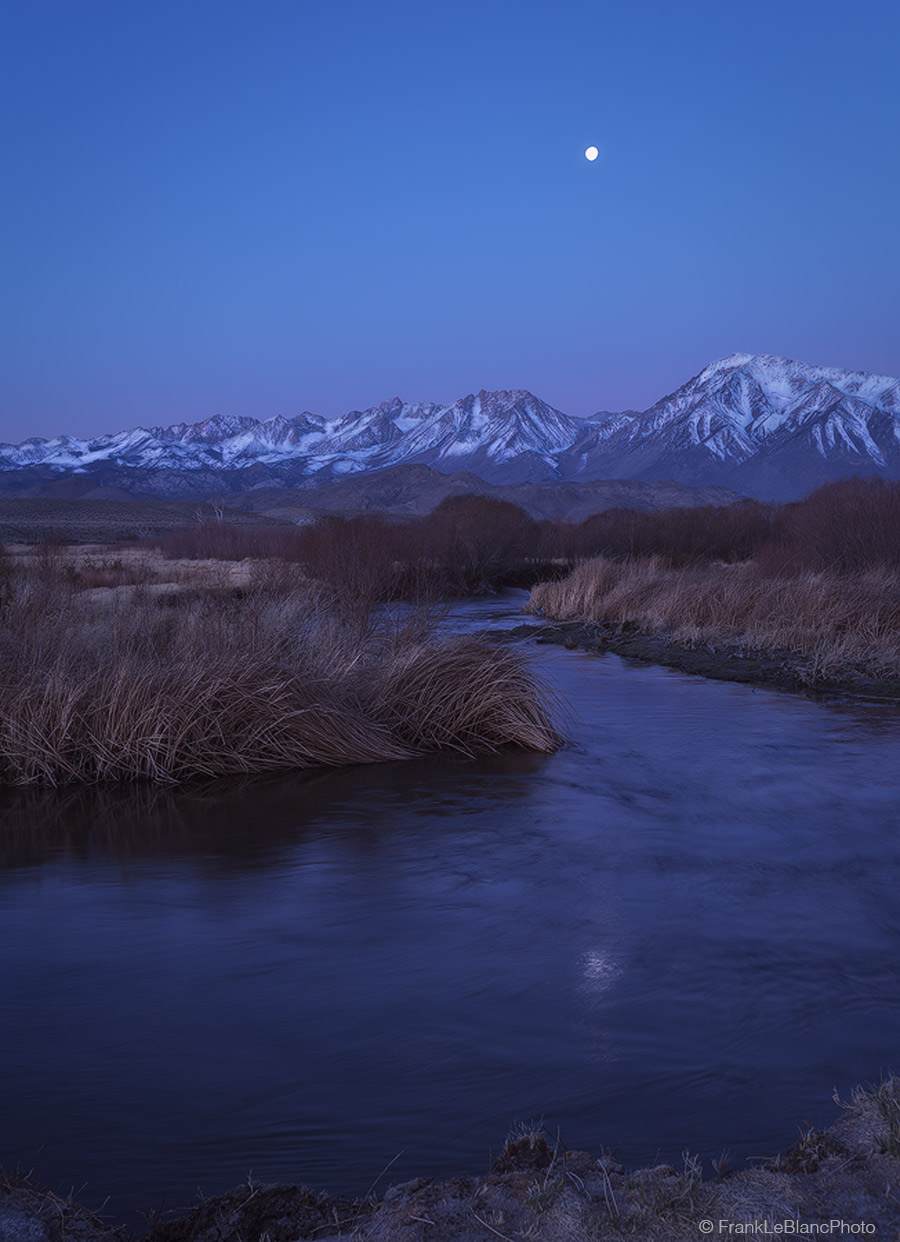 A waning gibbous moon hangs high over the sierra. The chill morning air shrouds the river and surrounding landscape in mist and...